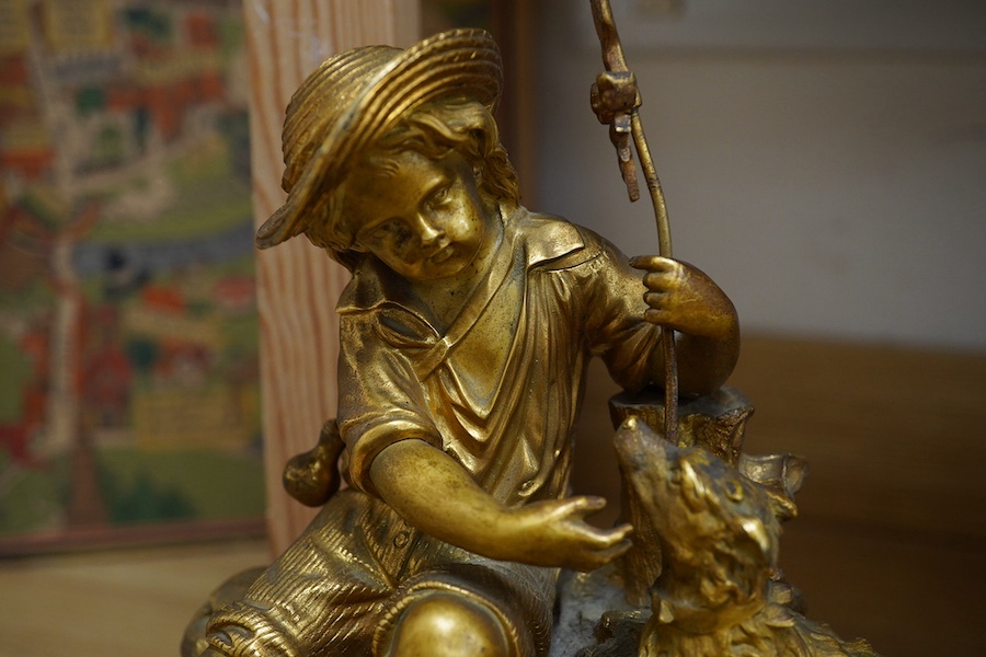 An early 20th century French ormolu clock surmounted with a boy and dog, striking on a bell, 41cm wide. Condition - fair, one hand missing, untested